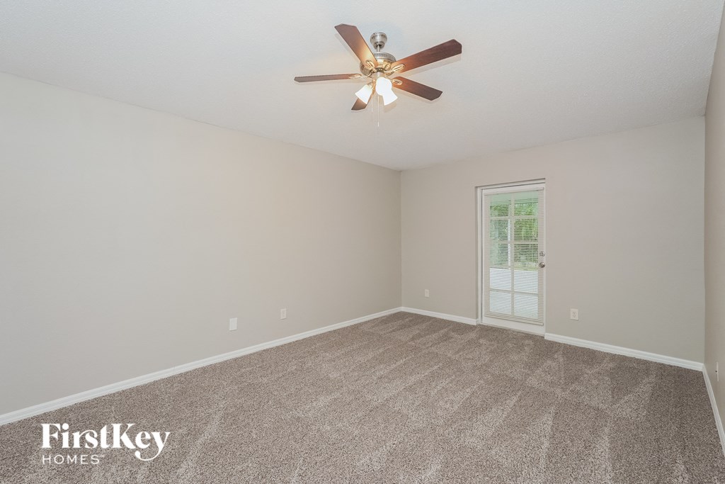 the living room of an empty house with a ceiling fan