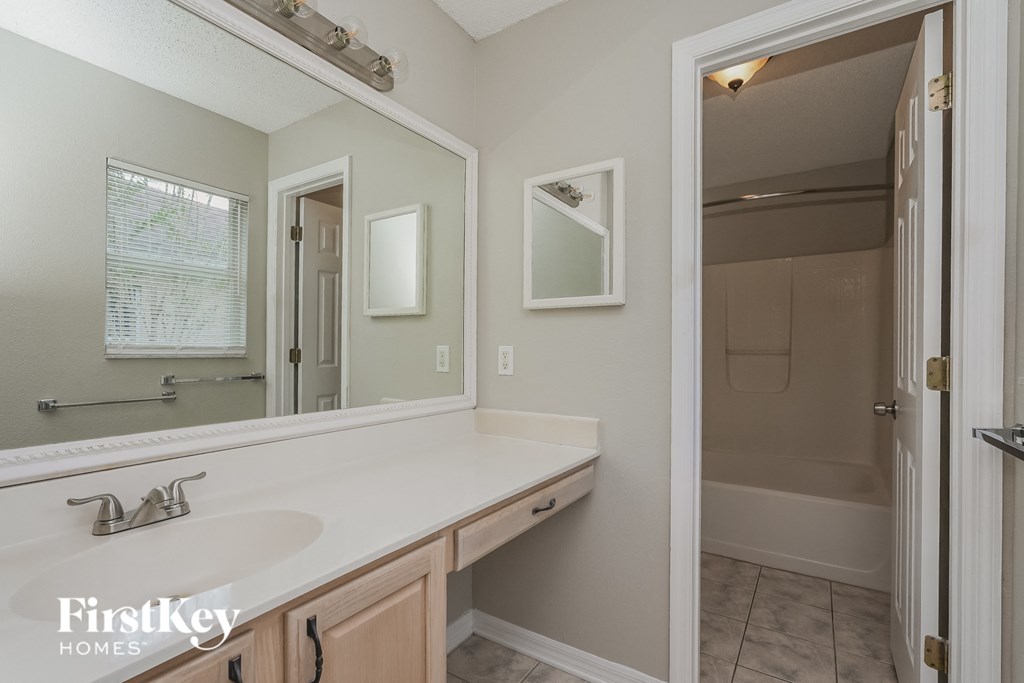 a bathroom with a large mirror and a sink and a shower