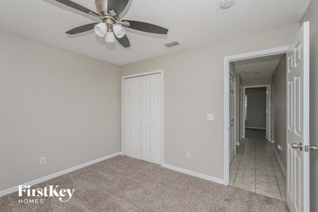 the living room of an empty house with a ceiling fan