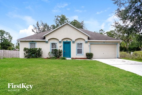 a white house with a blue door and a lawn