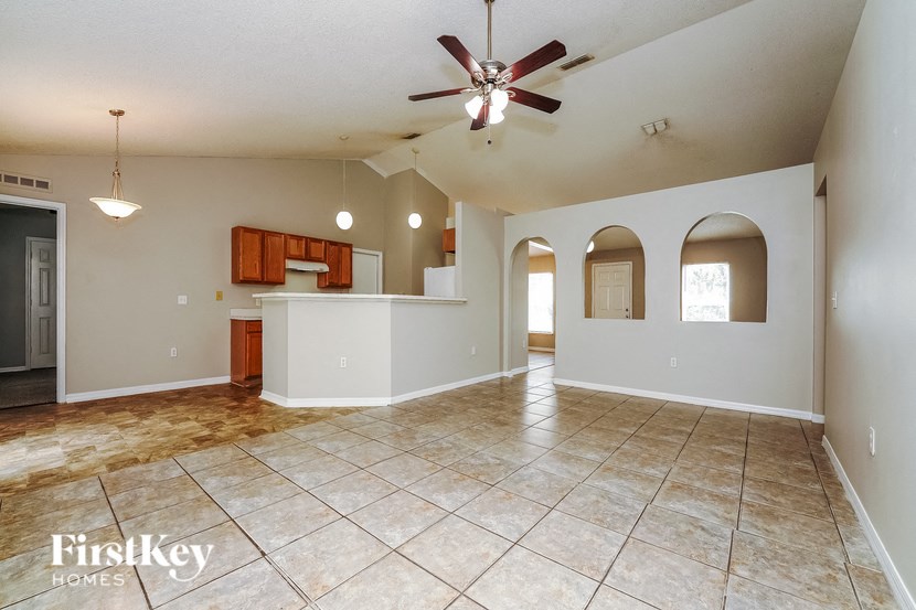 an empty kitchen and living room with a ceiling fan