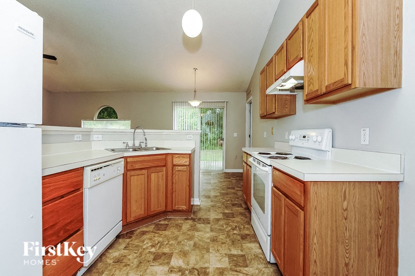 a kitchen with white appliances and wooden cabinets