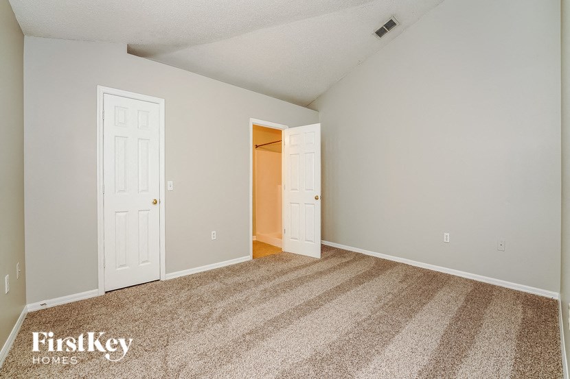 a bedroom with a door open to a closet     and a door
