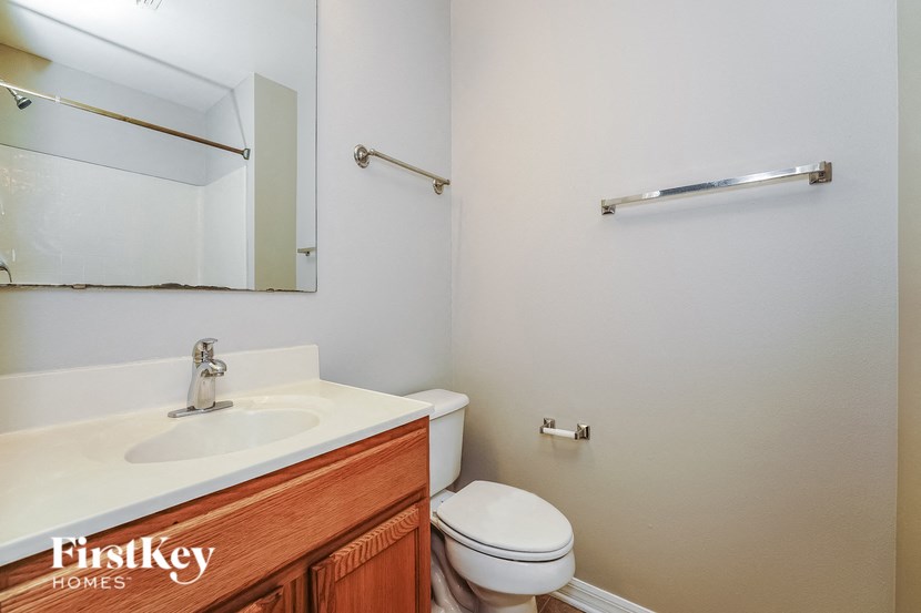 a bathroom with a sink toilet and a mirror