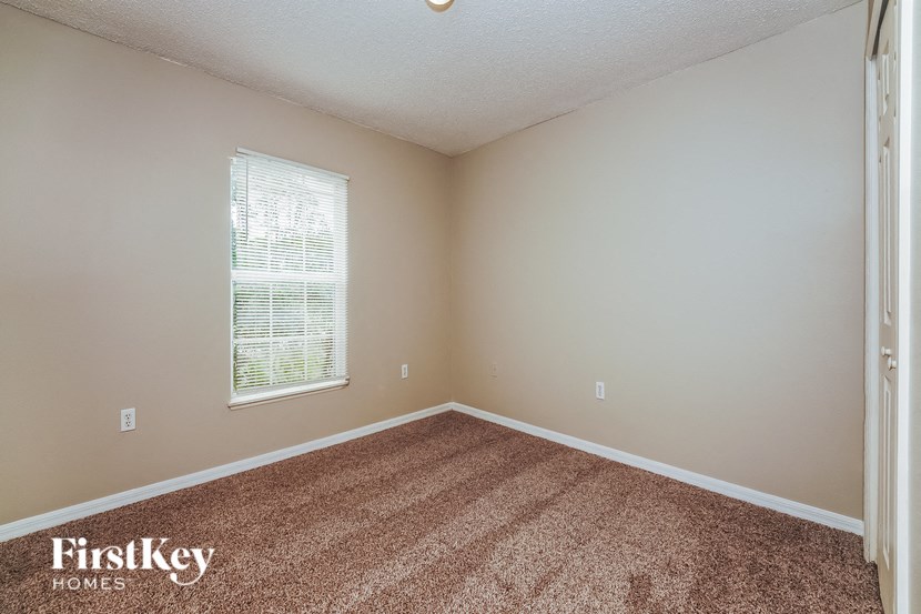 the living room of a home with carpet and a window