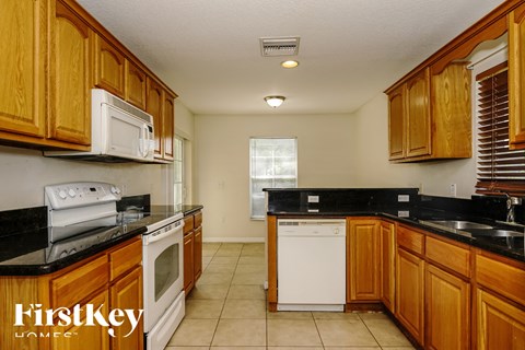 a kitchen with wooden cabinets and white appliances