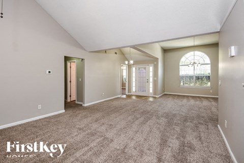 a spacious living room with carpet and a large window