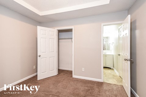 a bedroom with a closet and a door to a bathroom