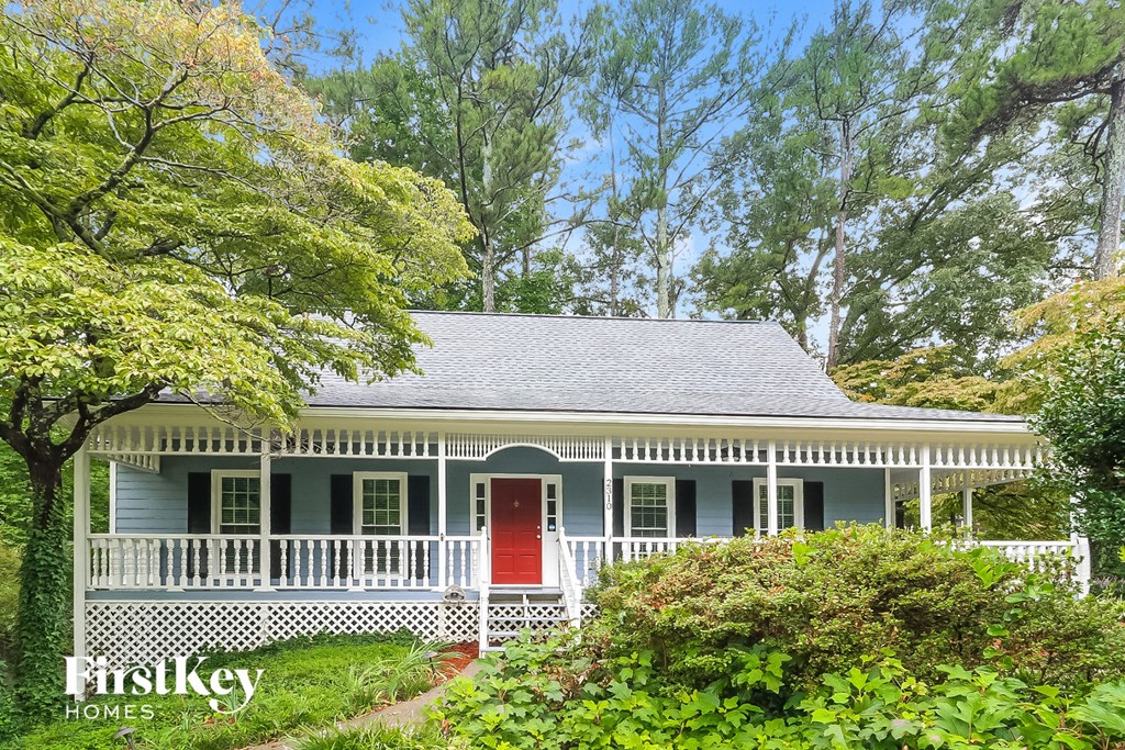 A blue house with a red door and a porch.