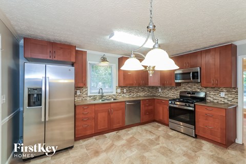 A kitchen with wooden cabinets and a refrigerator.