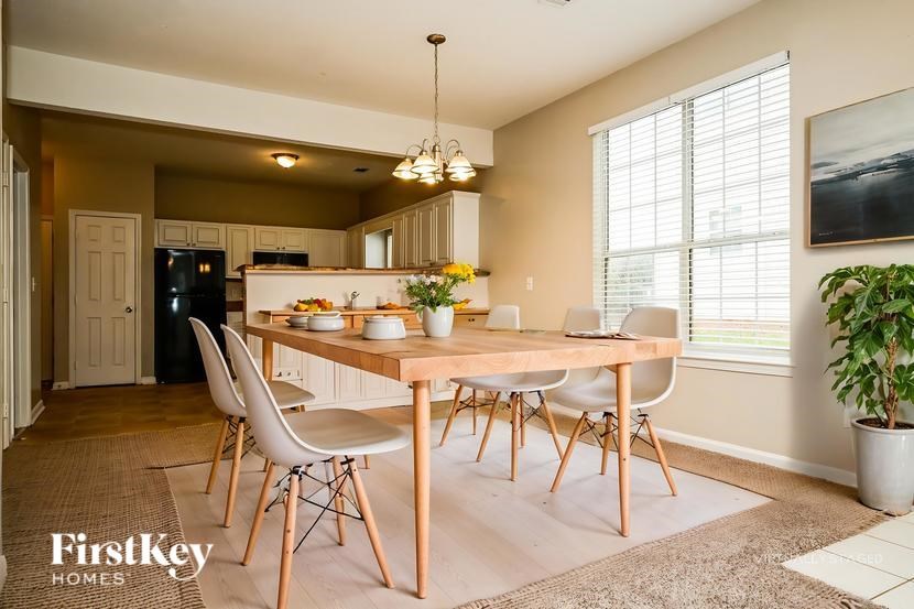 A dining room with a wooden table and chairs.