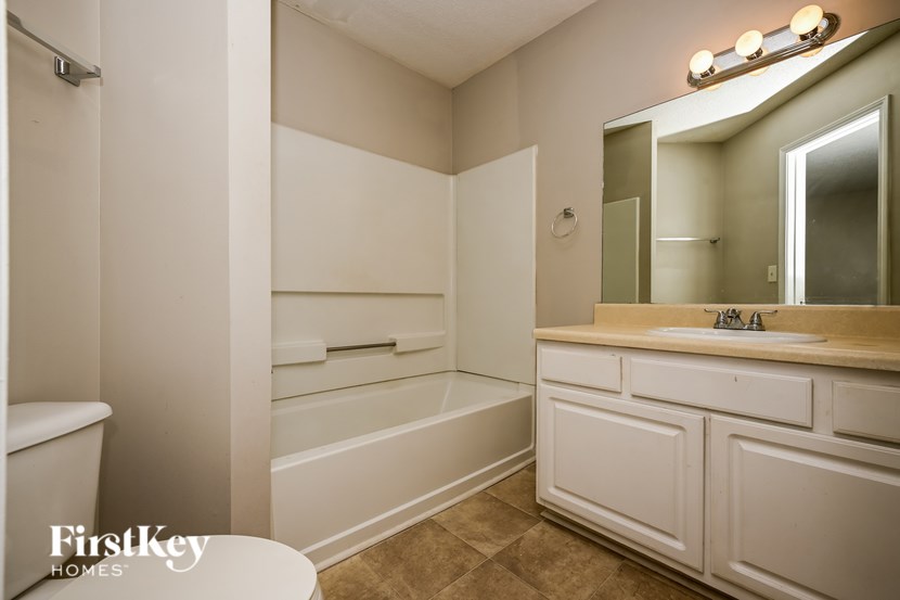 A white bathroom with a toilet, sink, and bathtub.