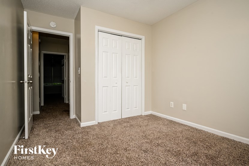 A room with a carpeted floor and a white door.