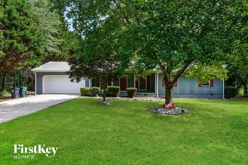 a home with a lawn and trees in front of it