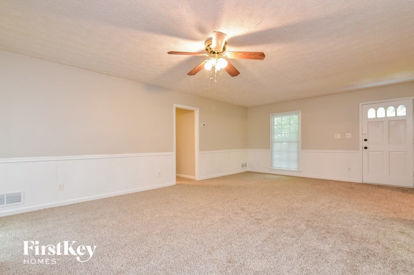 the living room of an empty house with a ceiling fan