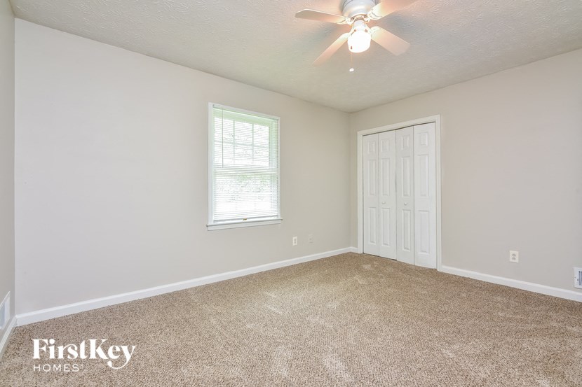 the living room of an empty home with a ceiling fan