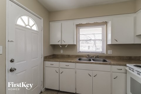 A kitchen with white cabinets and a sink.