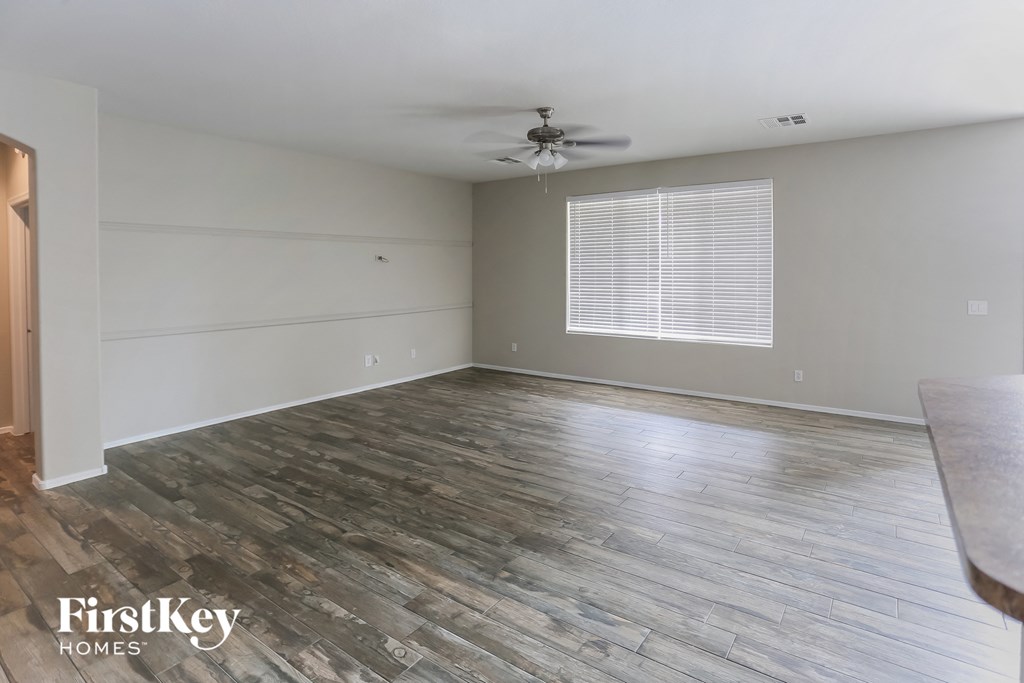 a living room with wood floors and a ceiling fan