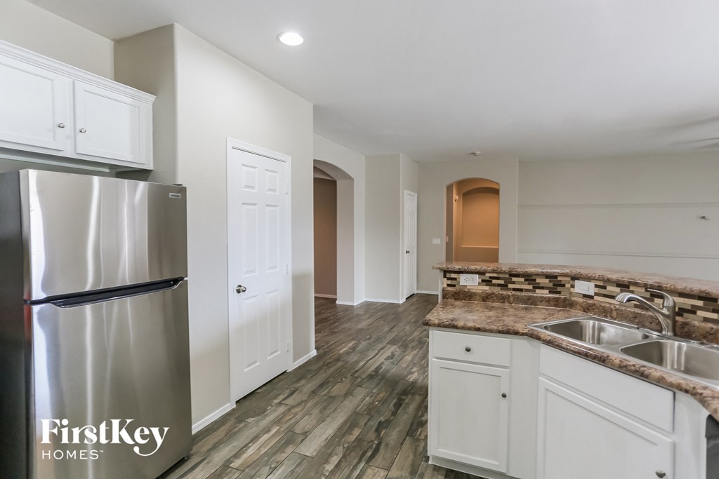 a kitchen with white cabinets and a stainless steel refrigerator