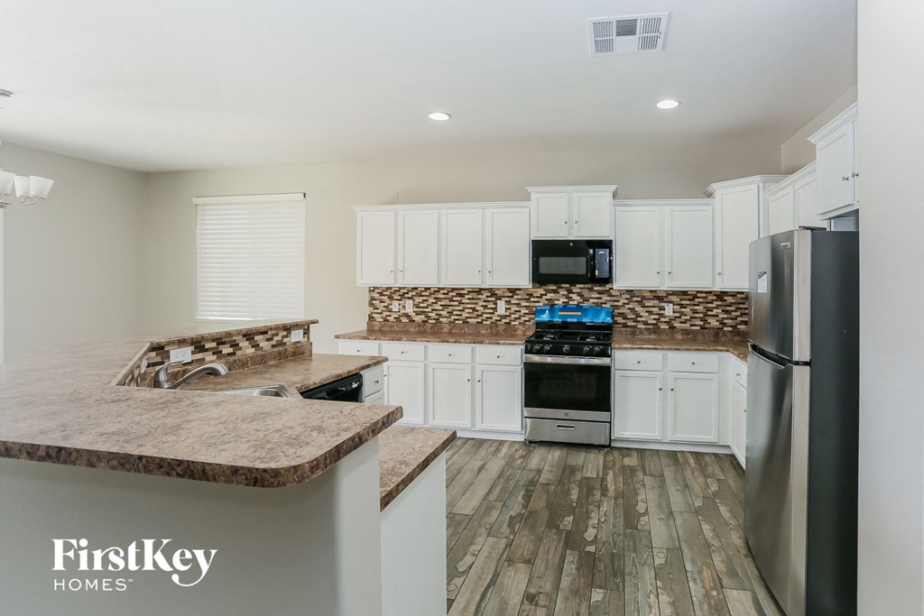 a kitchen with white cabinets and stainless steel appliances