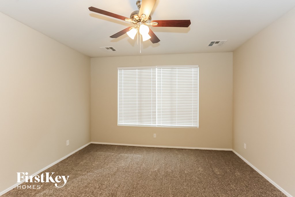 a empty room with a ceiling fan and a window