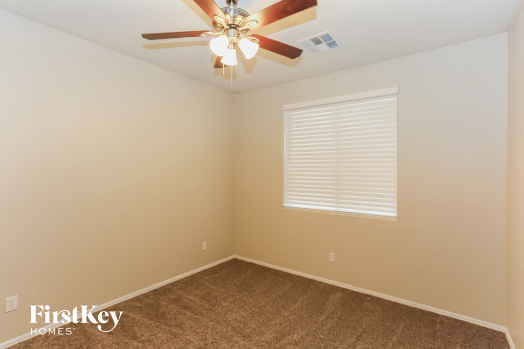a empty room with a ceiling fan and a window