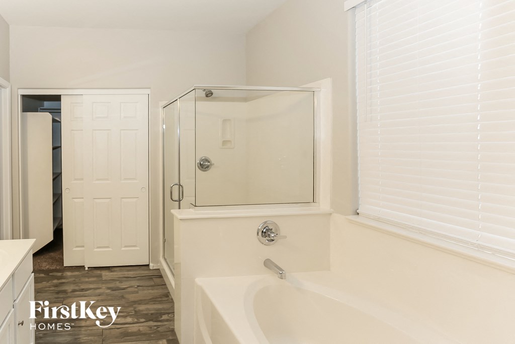 a bathroom with a tub and a shower and a white door