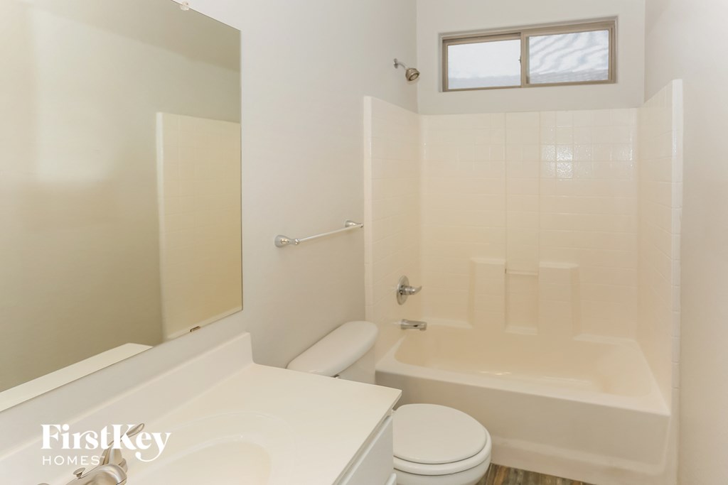 a white bathroom with a toilet and a tub and a sink