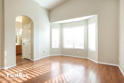 an empty living room with wood floors and windows