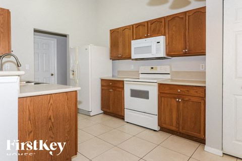 a kitchen with white appliances and wooden cabinets