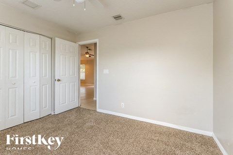 a bedroom with two closets and a carpeted floor