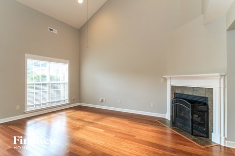 a living room with a fireplace and wooden floors