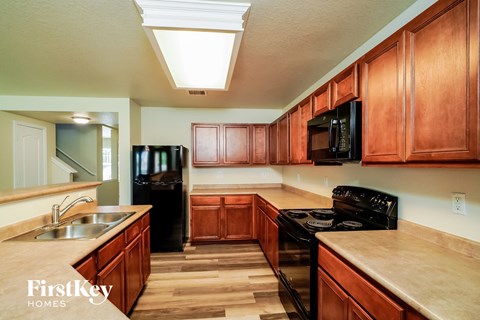 a kitchen with wooden cabinets and black appliances