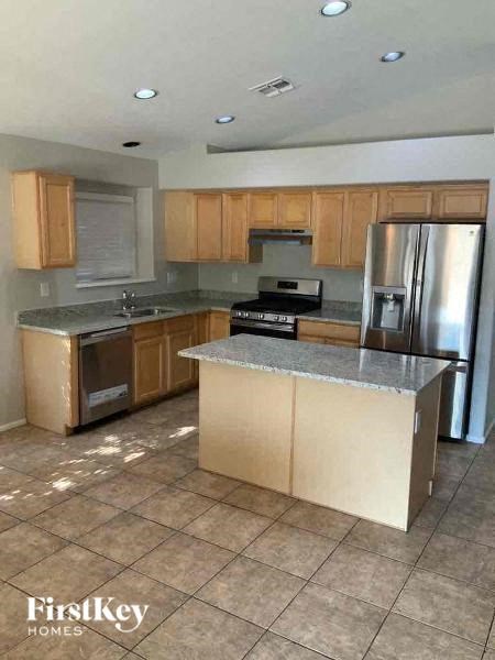A kitchen with wooden cabinets and a stainless steel refrigerator.