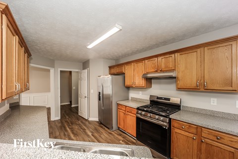 A kitchen with wooden cabinets and a stainless steel refrigerator.