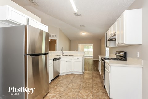 a white kitchen with stainless steel appliances and white cabinets