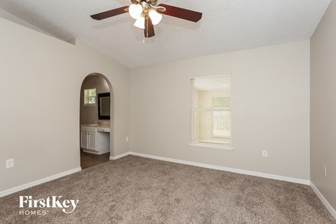 a living room with carpet and a ceiling fan