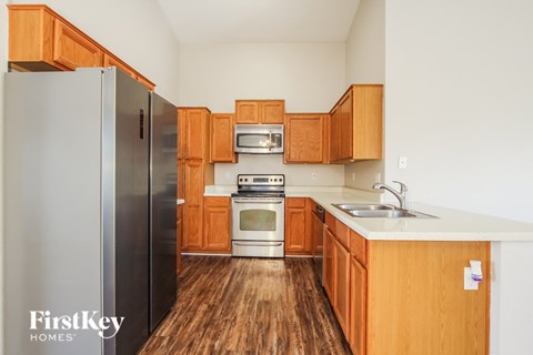 A kitchen with wooden cabinets and a stainless steel refrigerator.