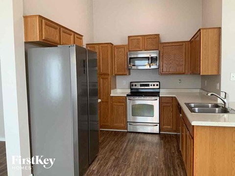 A kitchen with wooden cabinets and a stainless steel refrigerator.
