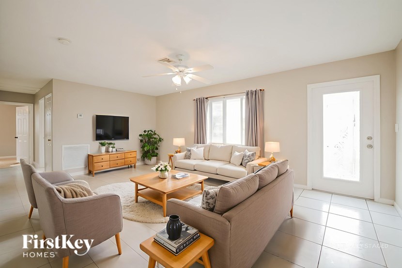 A living room with a couch, chair, and television.