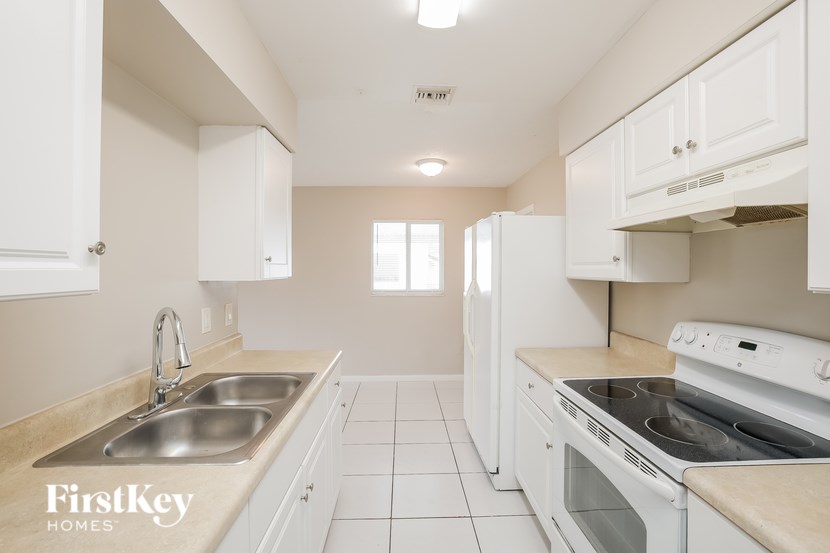 A kitchen with white cabinets and appliances.