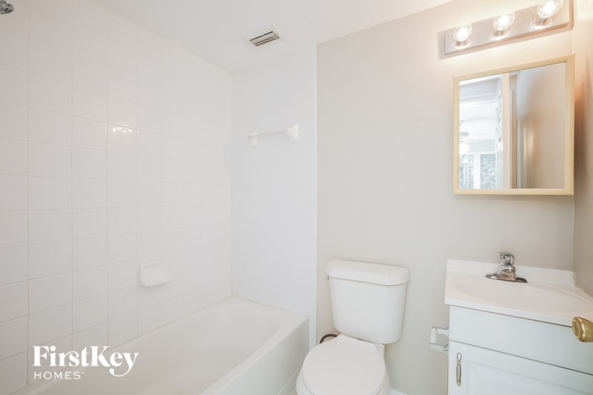 A white bathroom with a toilet, sink, and tub.