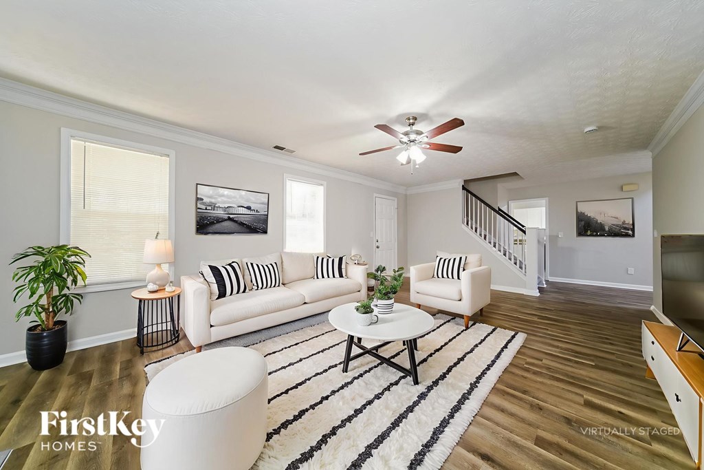 A living room with a white couch and a black and white striped pillow.