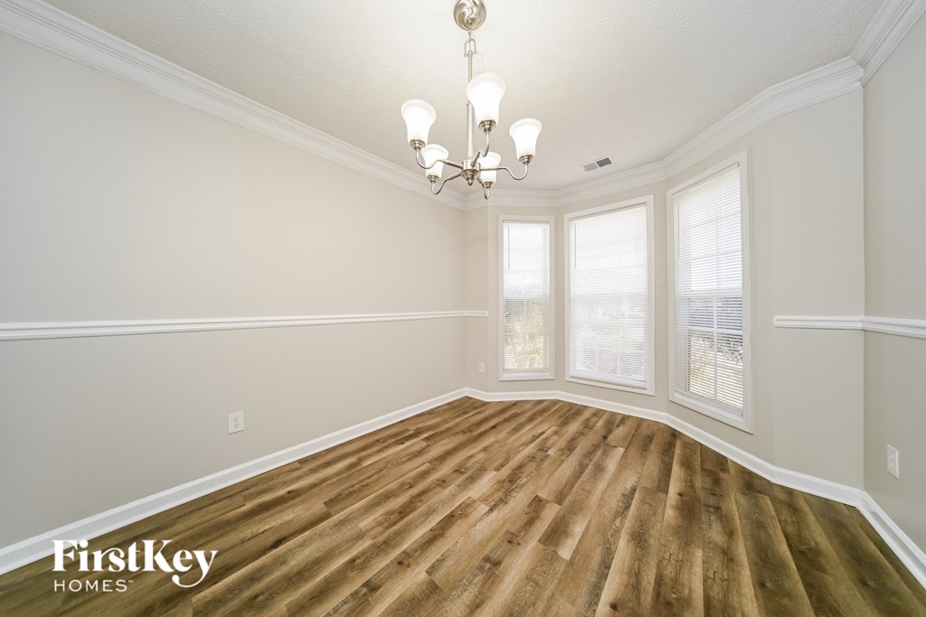 A room with wooden flooring and a chandelier.