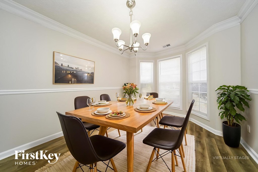 A dining room with a wooden table and chairs.