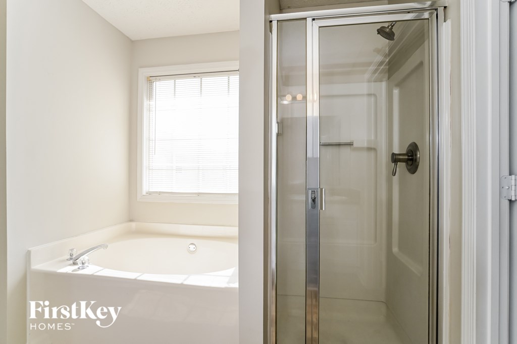 A white bathroom with a glass door shower.