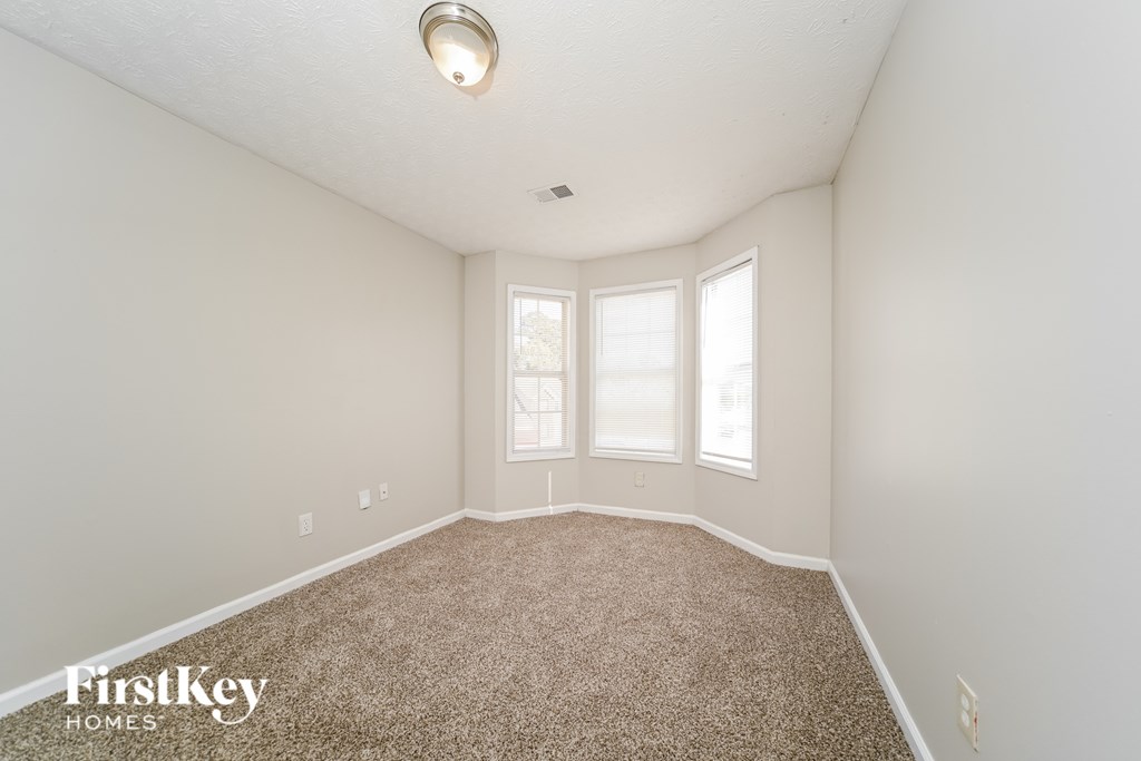 A room with a carpeted floor and a window.