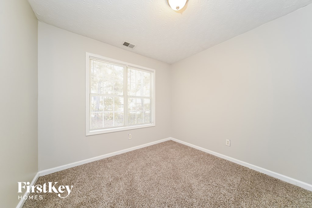 A room with a carpeted floor and a window.