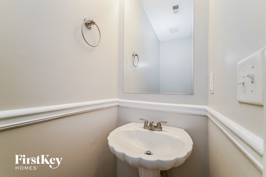 A small white sink in a small bathroom.