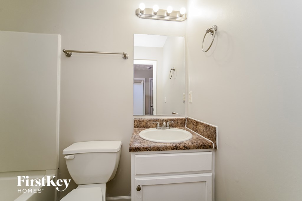 A white toilet sits next to a sink in a bathroom.